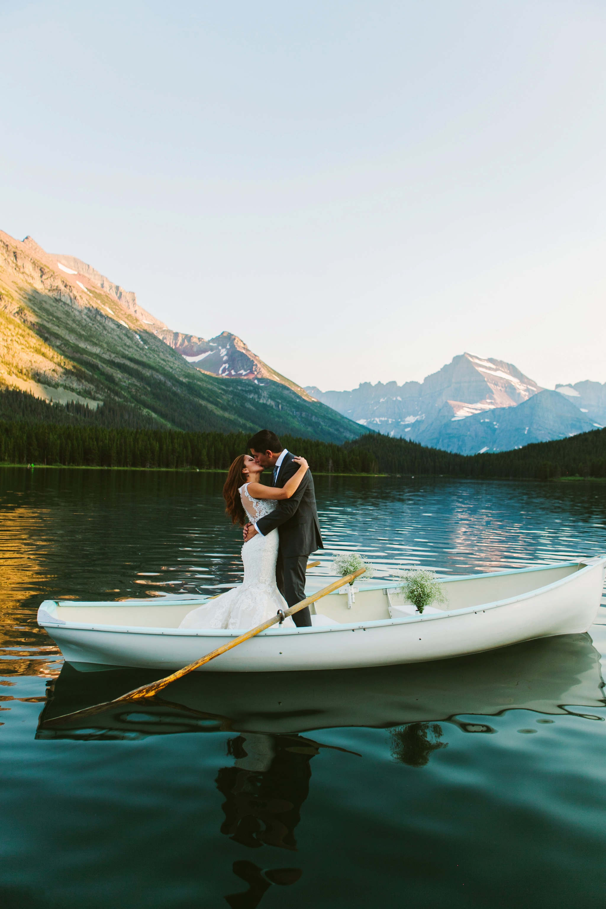 Glacier National Park Many Glacier Wedding Couple Kissing in Row Boat