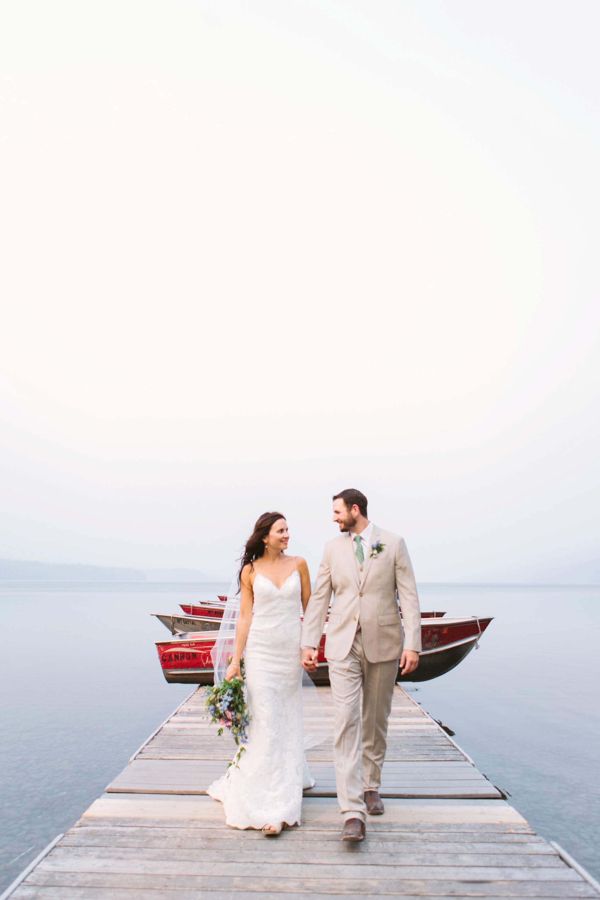 Glacier National Park Wildfire Wedding Couple on Lake McDonald Dock Holding Hands