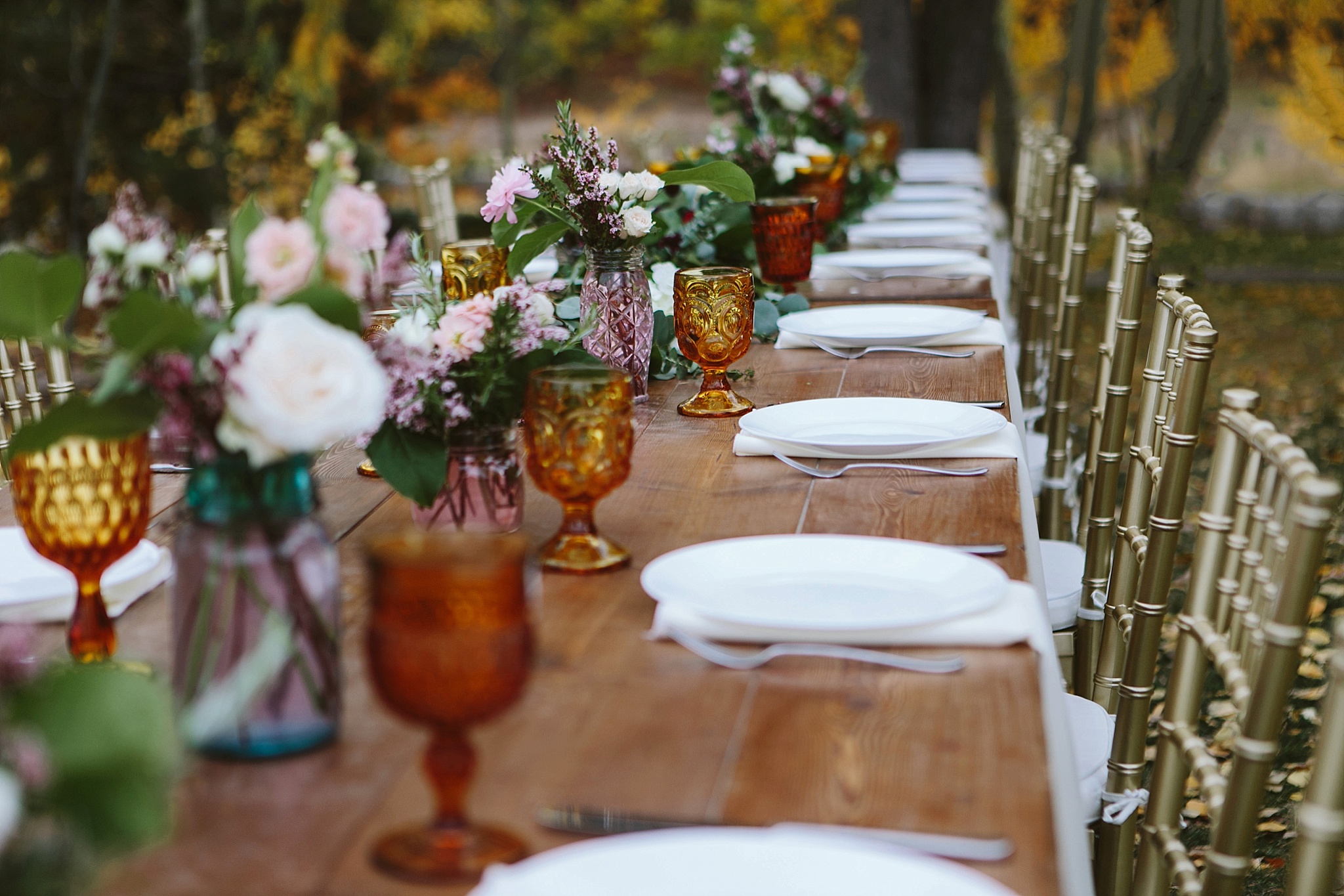Glacier National Park Rustic Farmhouse Table with Amber Glasses and Gold Chivari Chairs