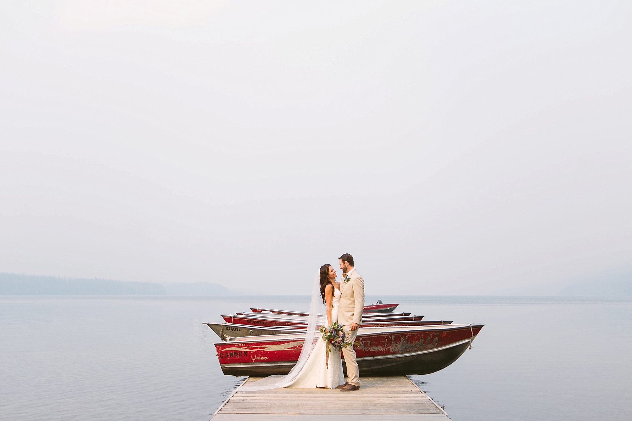 Glacier National Park Wedding Photos Bride and Groom Laughing on Dock at Lake McDonald