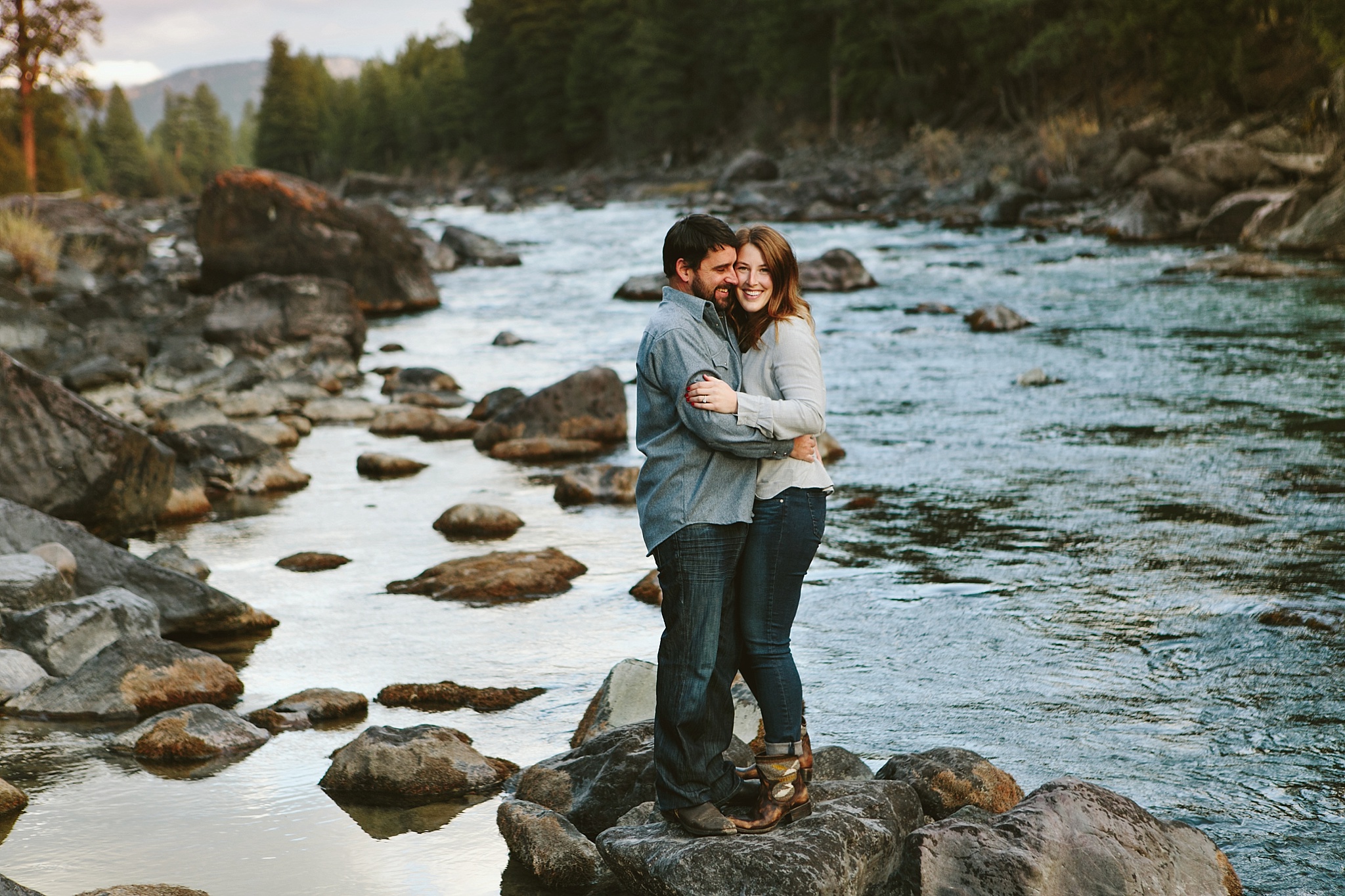 Missoula MT Engagement Photos Bride and Groom Hugging on Rocks at the River