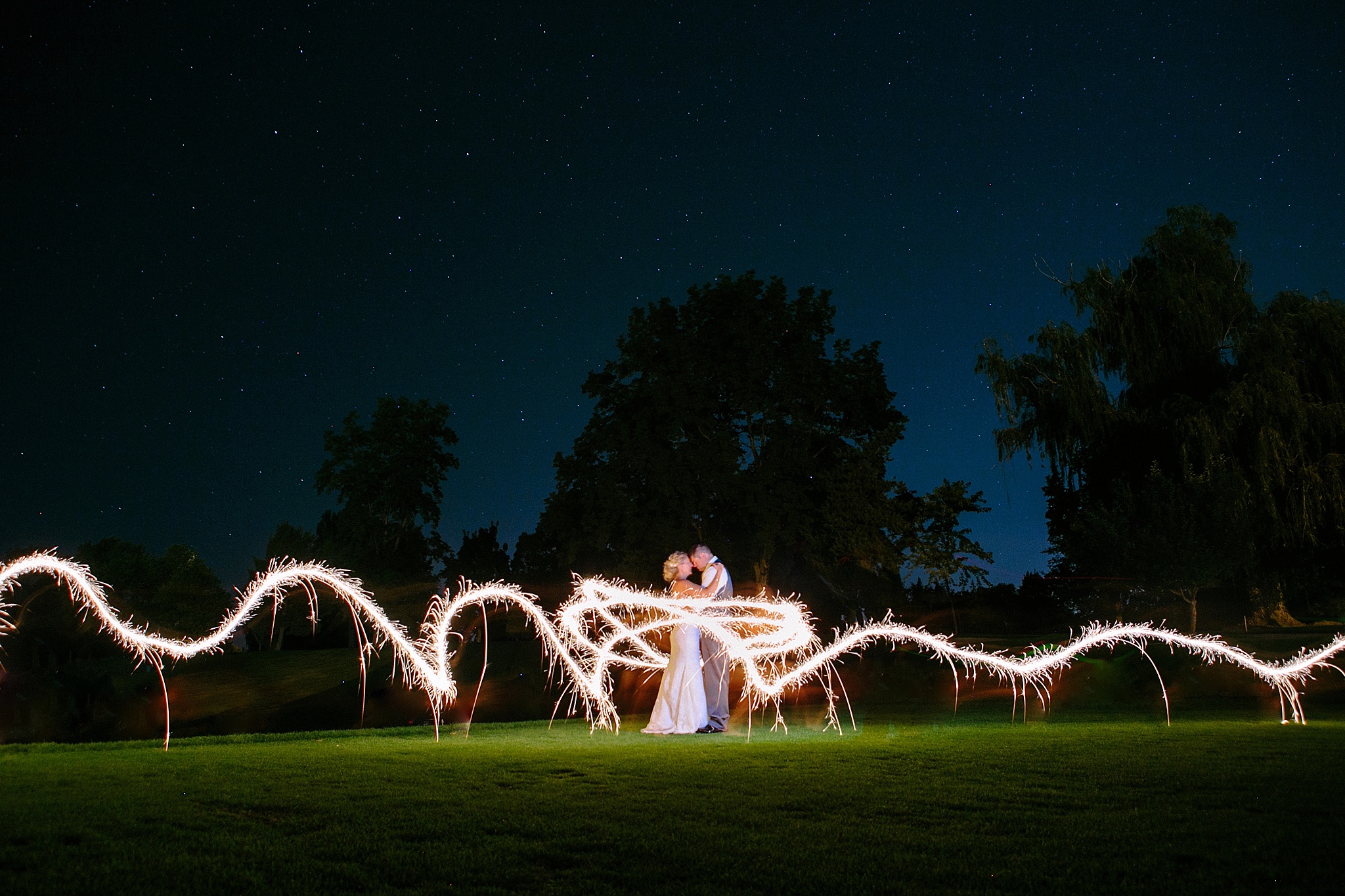 Missoula MT Country Club Wedding Photos Bride and Groom Kissing with Sparklers