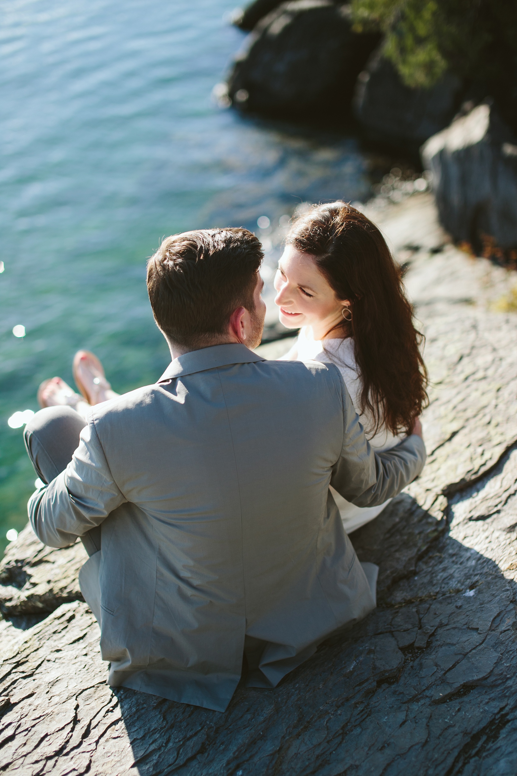 Bigfork MT Flathead Lake Engagement Photo Wayfarer Park Couple Sitting on Cliff
