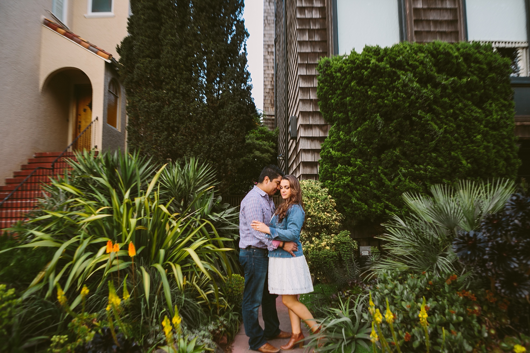 San Francisco CA engagement photo couple embracing along garden walkway at sunset