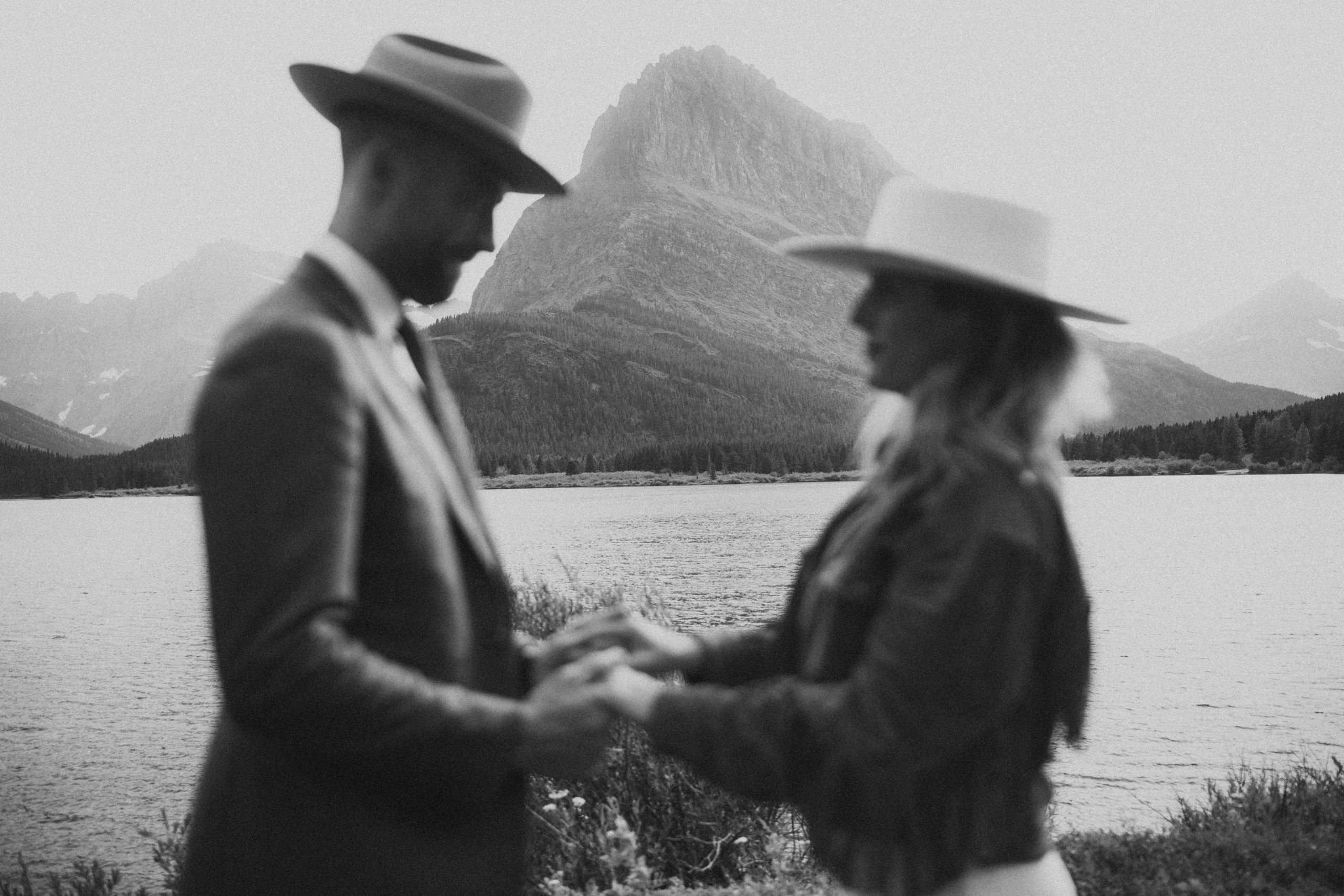 bride and groom holding hands in front of the mountains in Glacier National Park