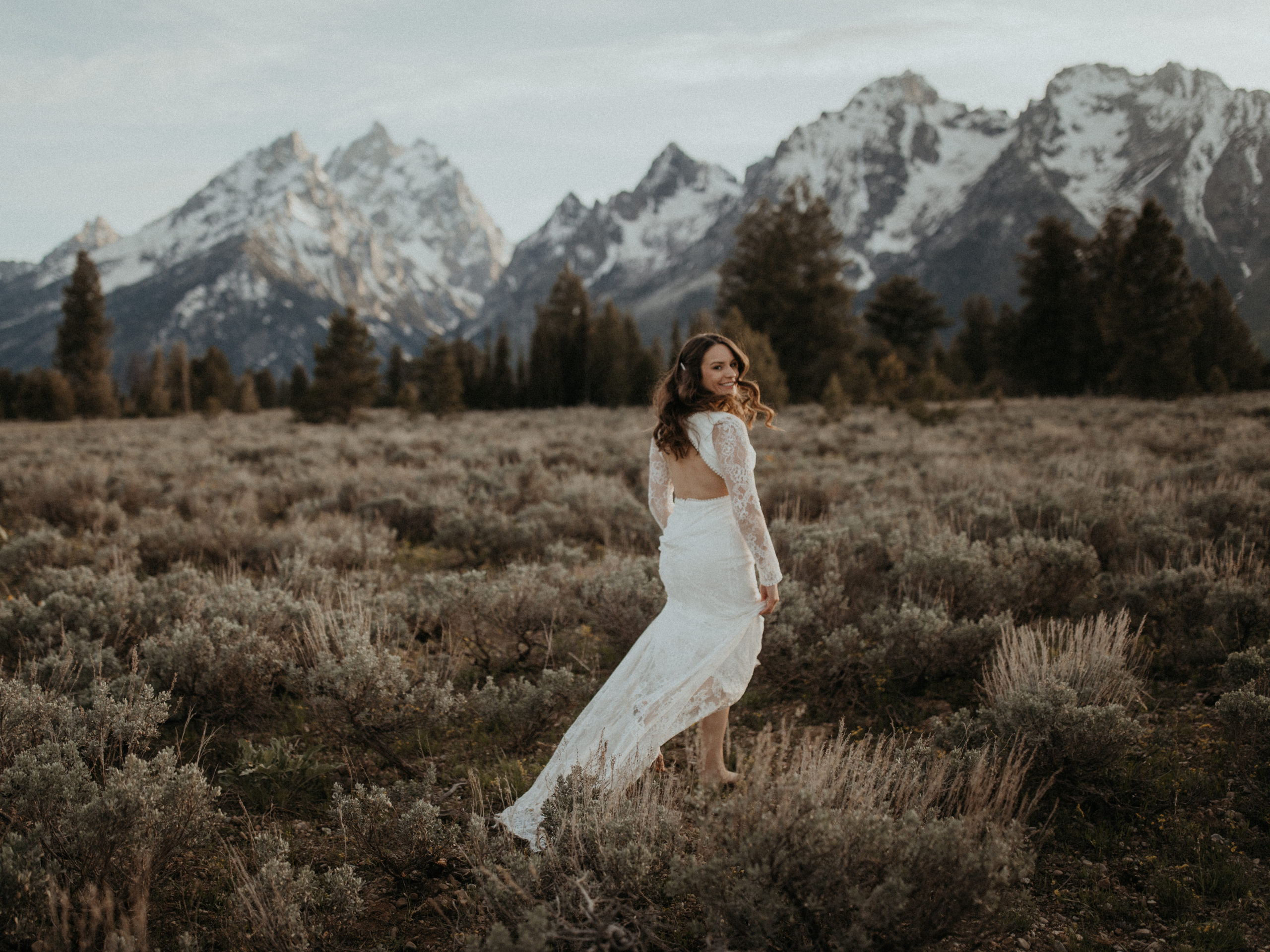 Bride running barefoot at sunset in the Grand Tetons National Park