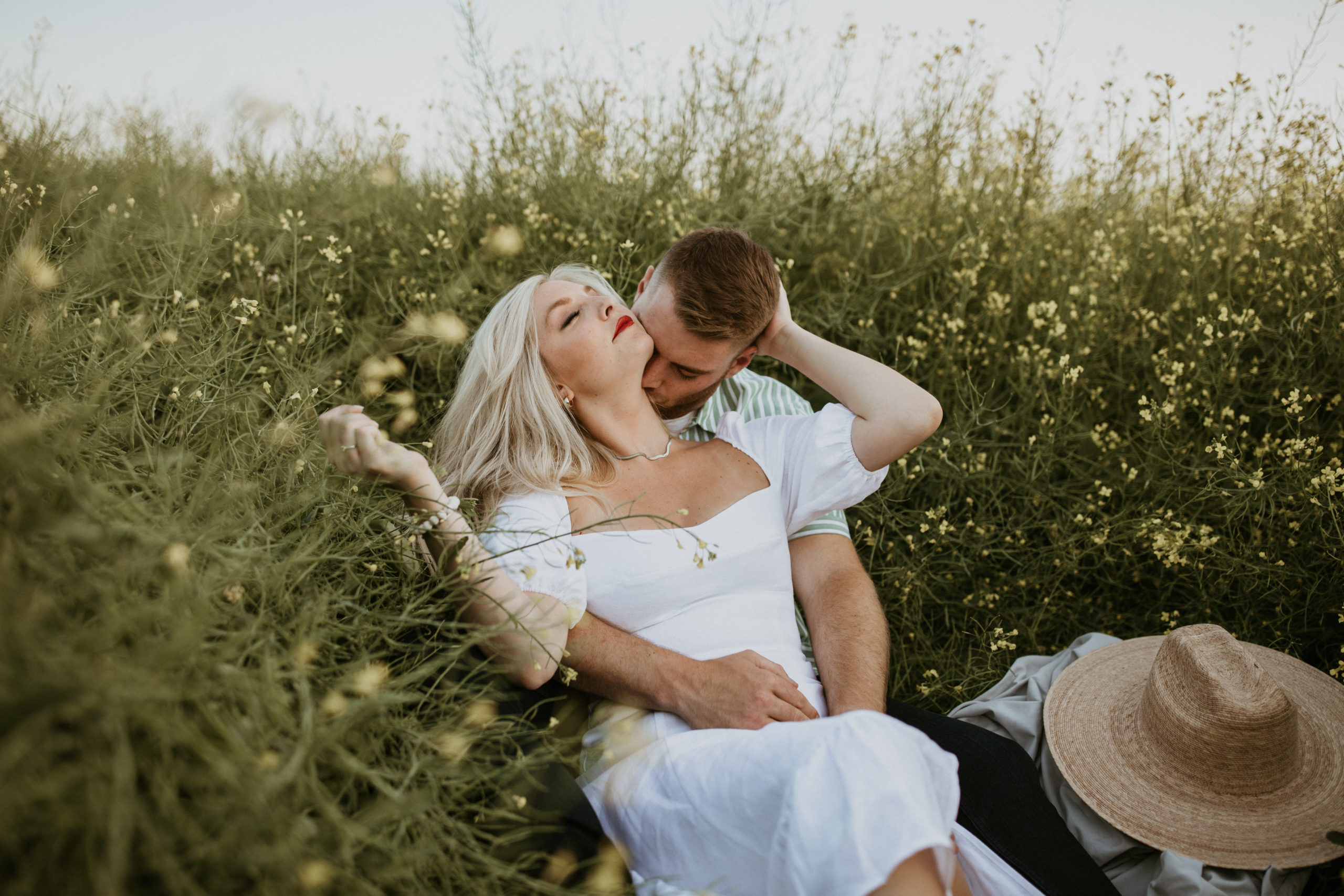 Summer engagement photos laying in wildflower field at sunset
