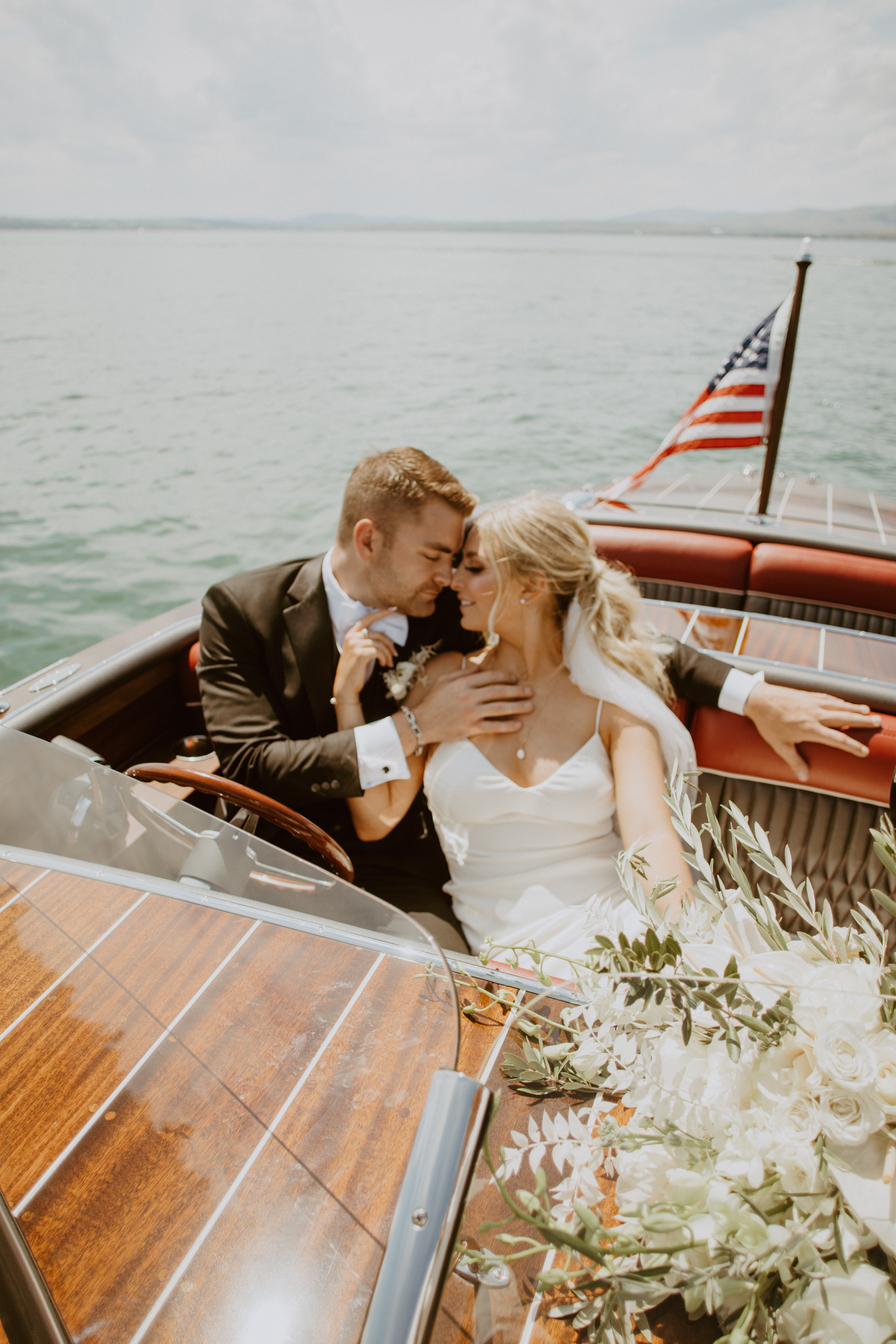 Sweet couple embracing in a boat on their wedding day on Flathead Lake MT