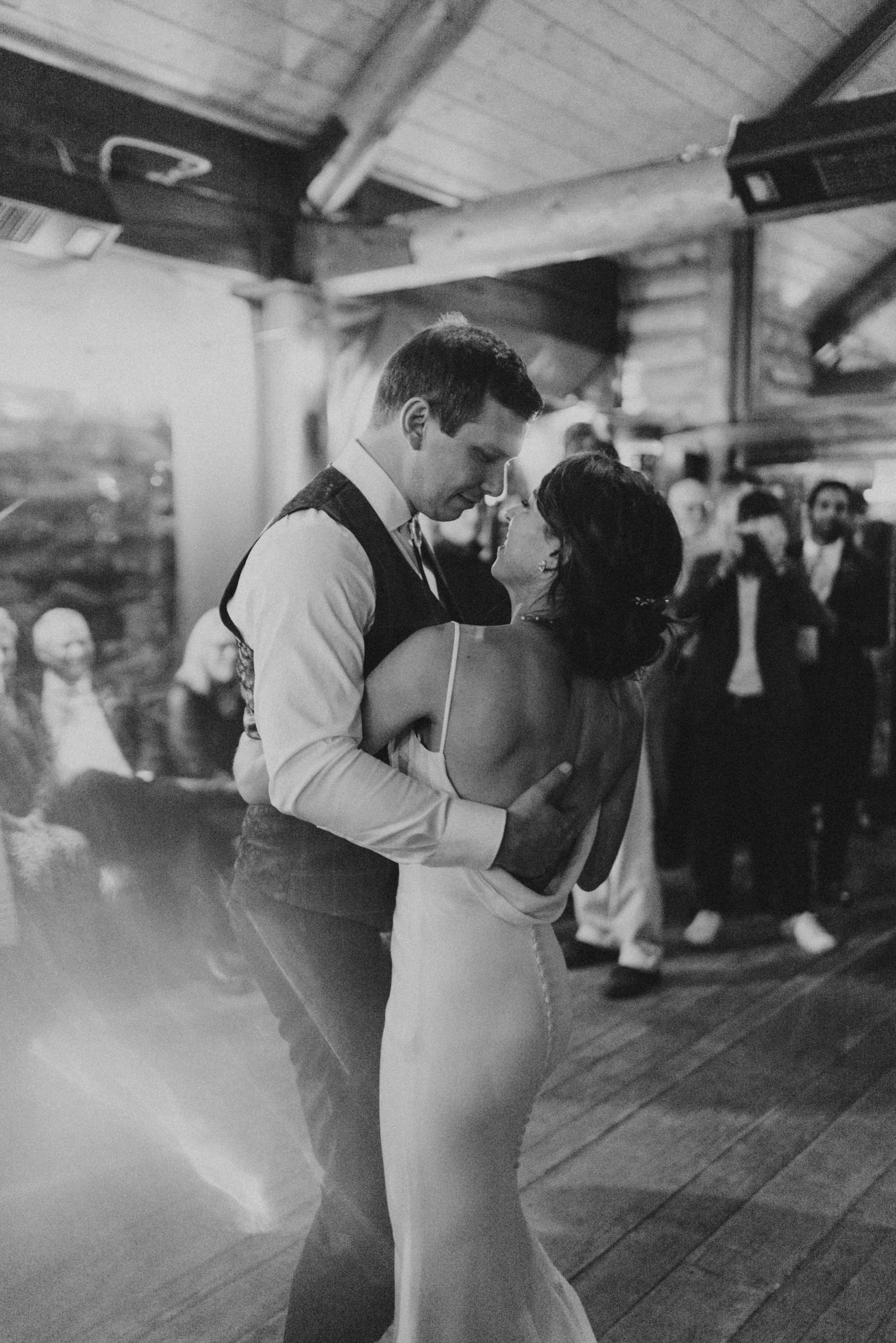 black and white winter bride + groom dancing in candlelight